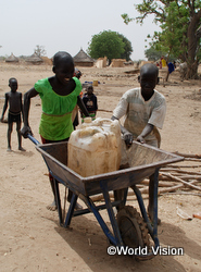 井戸から汲んだ水を運ぶ子どもたち