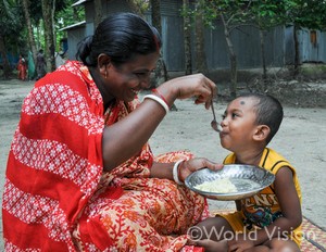 バングラデシュにおける支援で栄養改善の指導を受けた母親がこどもに食事をさせている様子
