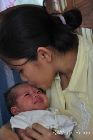 台風３０号（通称ハイエン）の嵐の中で生まれた子どもに愛おしそうに口づけする母親