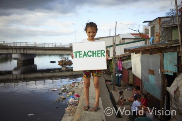 奥に見える橋の下で暮らすアニンちゃん(7歳)厳しい環境でも学校に通い、先生になるという夢を持っています