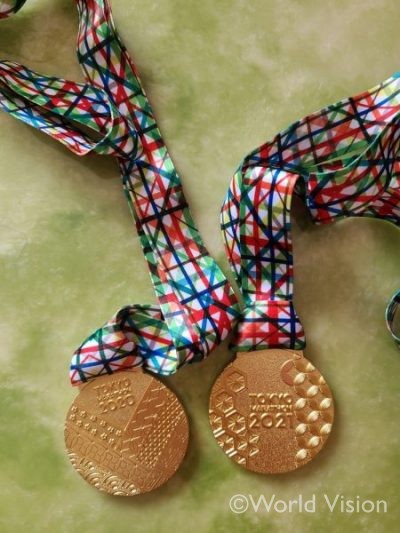 左：中止になった2020大会のメダル、右：今回完走した記念メダル