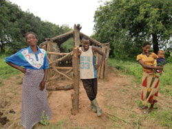 ンポレレさん（左・女性）とその息子と娘　 後ろは家族で建てた牛舎