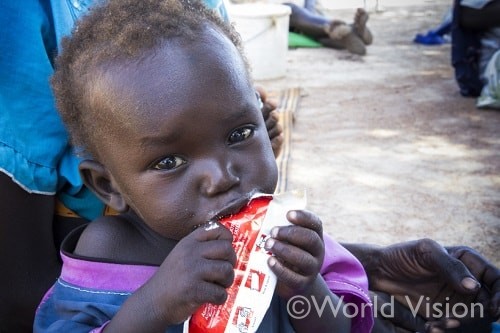 プランピーナッツという栄養治療食を食べる南スーダンの子ども