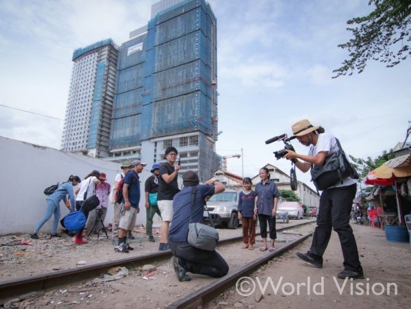 線路脇のスラムで撮影中の亀山ディレクターとカメラマン（カンボジア）