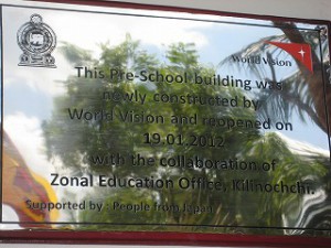 園舎の壁に埋め込まれた真新しいプレート。 「この幼稚園の園舎はキリノッチ教育局の協力を得て、ワールド・ビジョンによって新しく建設され、2012年1月19日に再開した。日本の人々の支援による。」