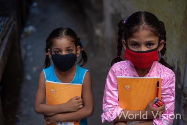 ワールド・ビジョンが学校に行けない子どもたちのために開いたインフォーマルスクールに通うマスク姿の女の子（インド）
