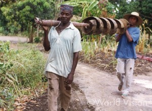 井戸建設の道具や資材を運ぶ村の人々