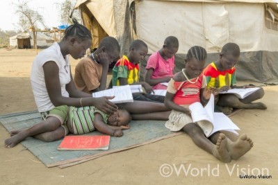 テントの外で本を広げる子どもたち。両親は南スーダンから戻らず、兄弟だけで暮らしている