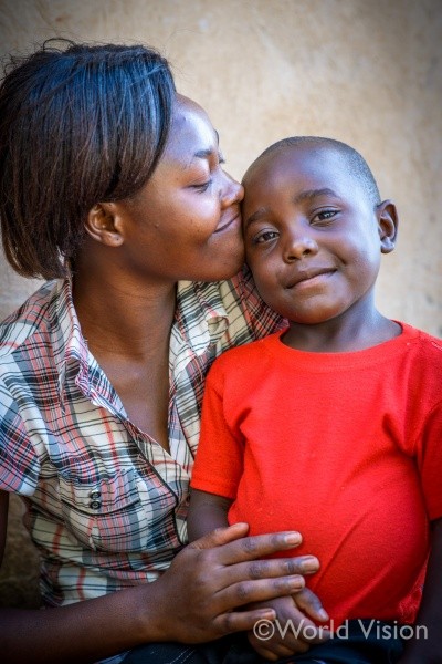 お母さんの腕の中で微笑む男の子。（ウガンダ）どの子どもにも、「生きる権利」「守られる権利」「育つ権利」「参加する権利」がある