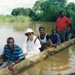 丸木舟で川を渡る筆者（前から2番目）。みんな笑顔だがこの川にワニがおり常に周囲に注意している（1999年撮影）