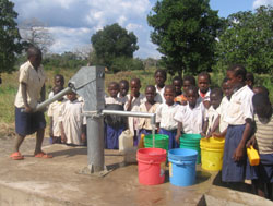 タンザニアのチャイルド・スポンサーシップによる支援地域にできた給水ポンプで水くみする子どもたち