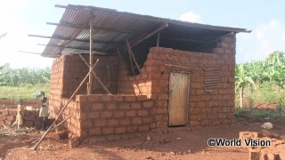 支援を受けたトタン屋根で建設中の家